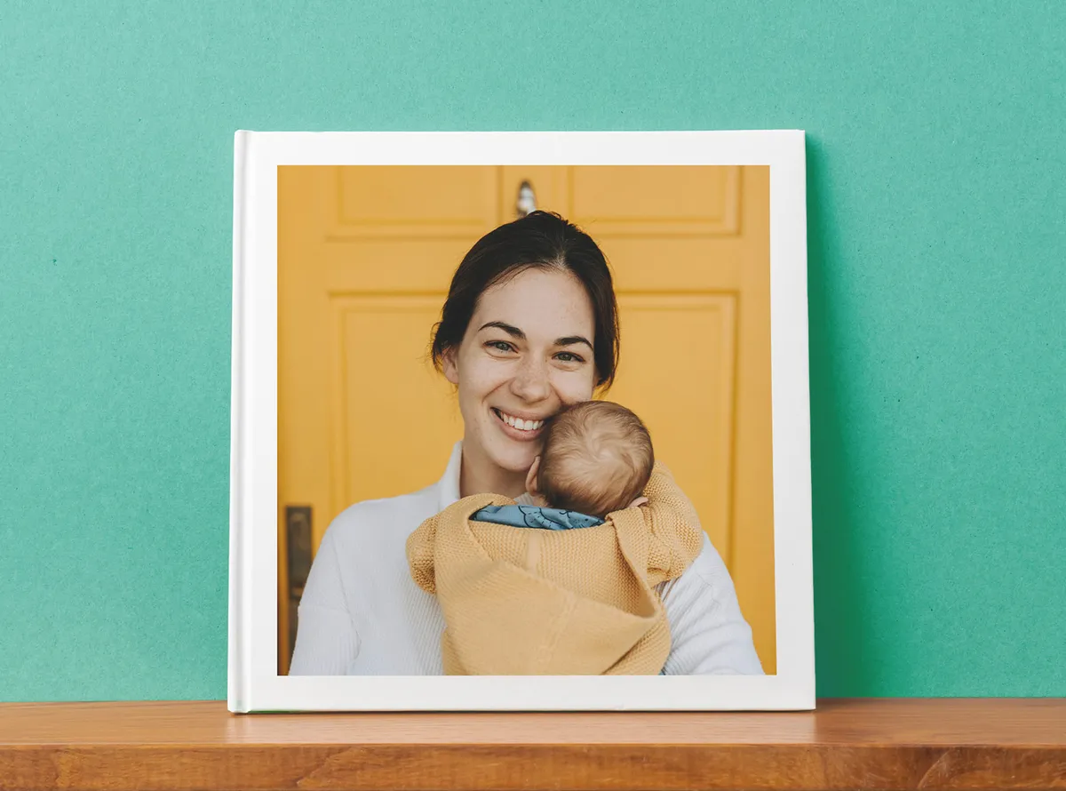 Fotobuch Cover mit einem Motiv einer Mama mit Baby auf dem Arm